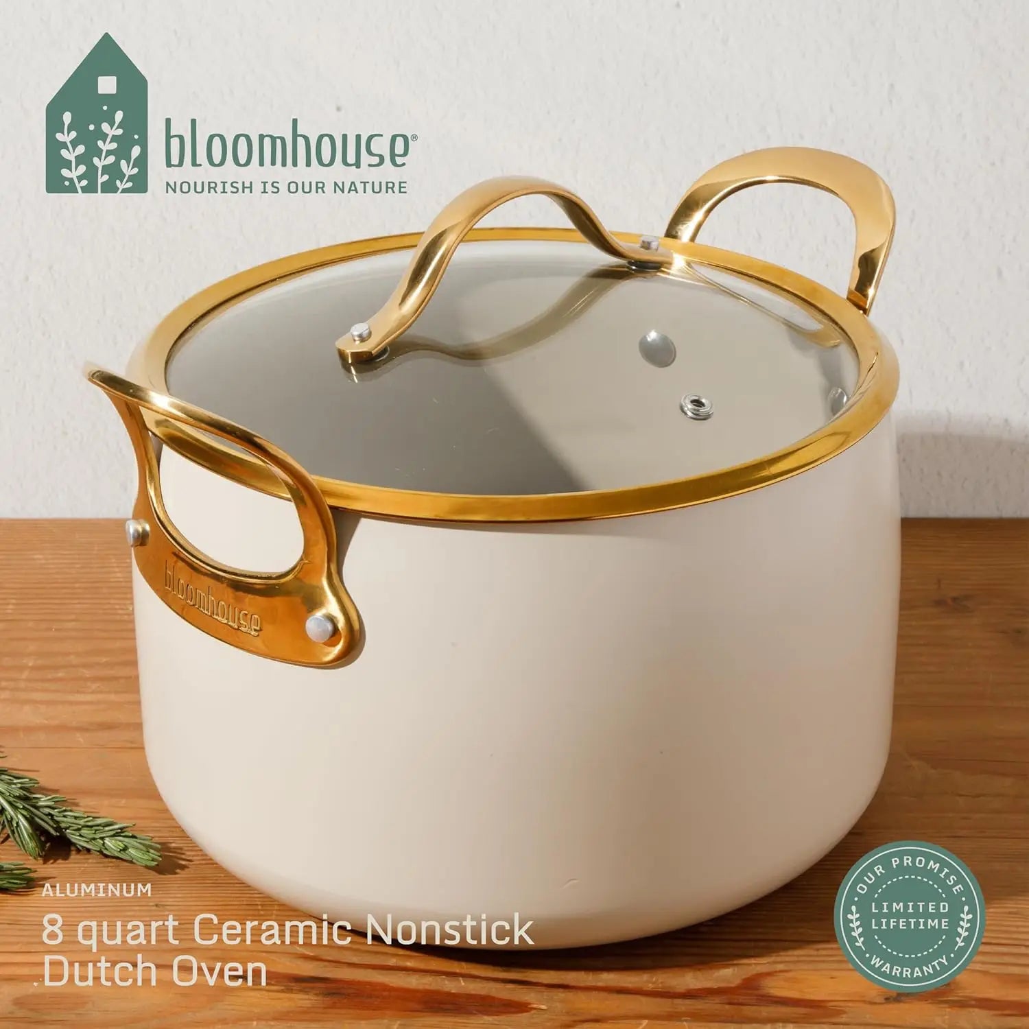 Almond ceramic nonstick Dutch oven with gold handles on a wooden surface, featuring the Bloomhouse brand.