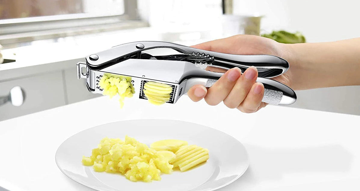 Garlic press being used to crush garlic with images of food in the background